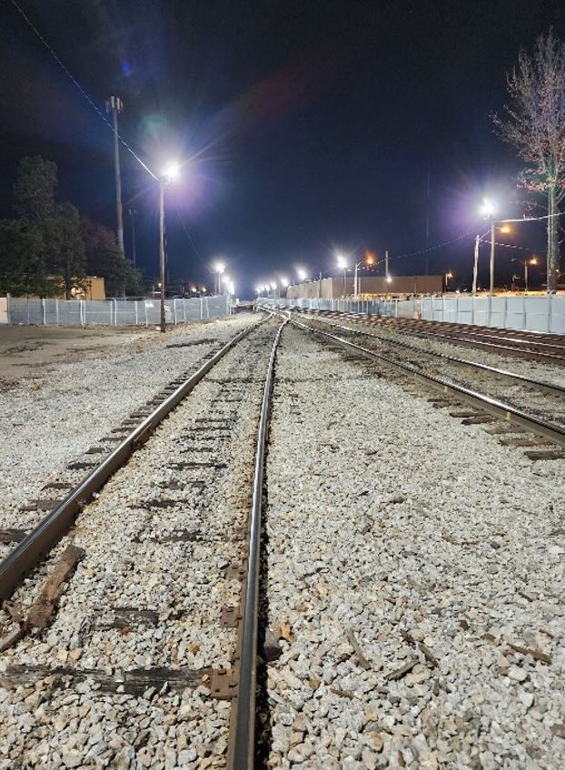Tracks in rail yard illuminated by strong lighting