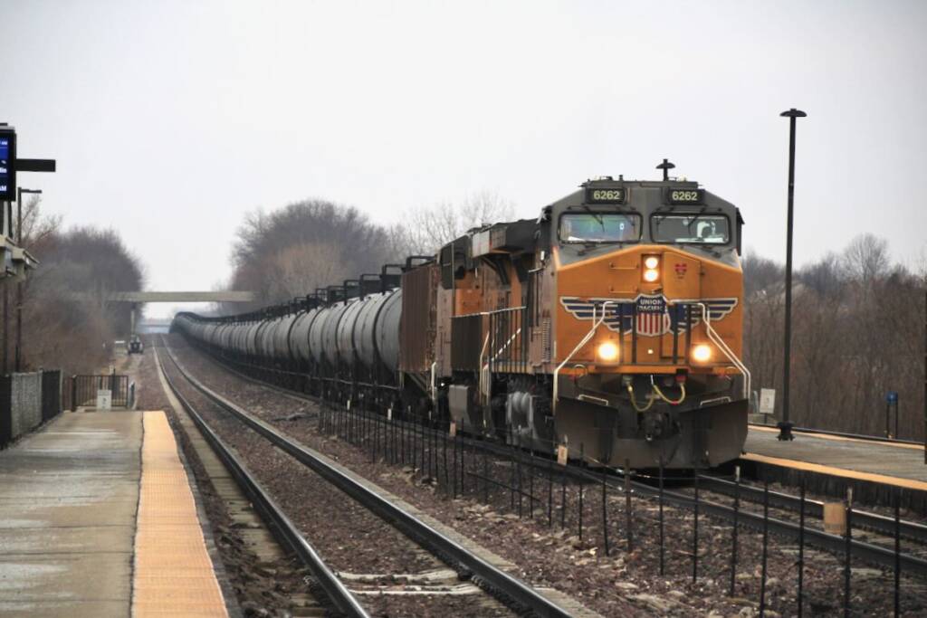 Unit train of tank cars at commuter rail station