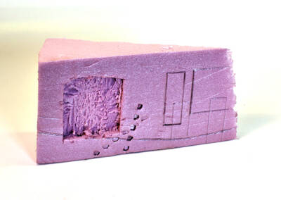 a thick piece of pink insulation foam carved into a trapezoidal block