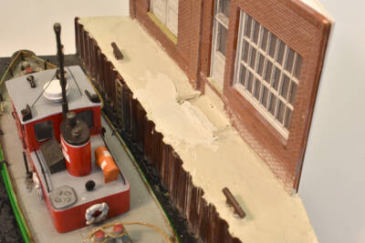 anchor cement poured between plastic bulkhead wall and brick warehouse wall with lumpy area near door