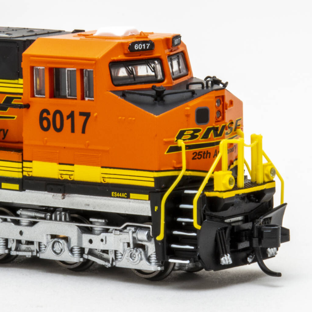 Color photo of showing nose of a modern N scale diesel locomotive painted orange, black, and silver on white backdrop.