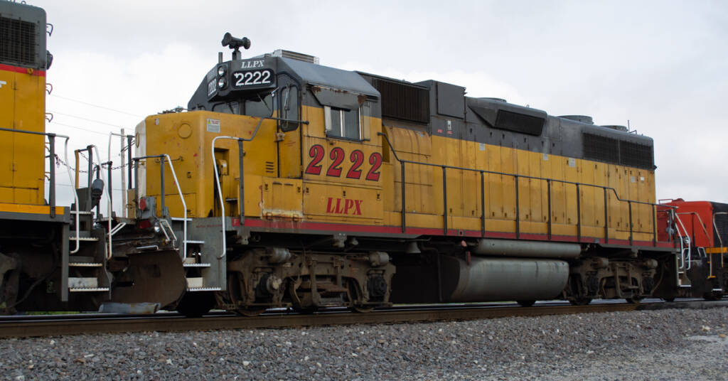 Color photo of EMD hood unit painted yellow and gray with red graphics.