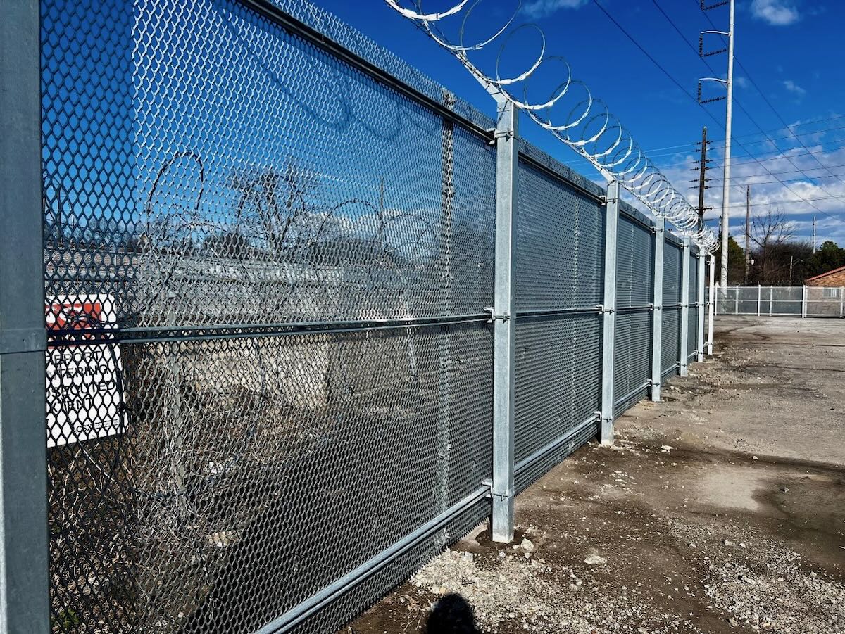 Chain link fence with barbed-wire on top.