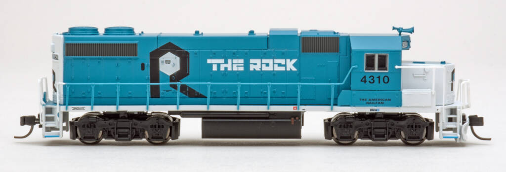 Color photo showing engineer’s side of N scale EMD hood unit painted blue and white with black and white graphics on white background.