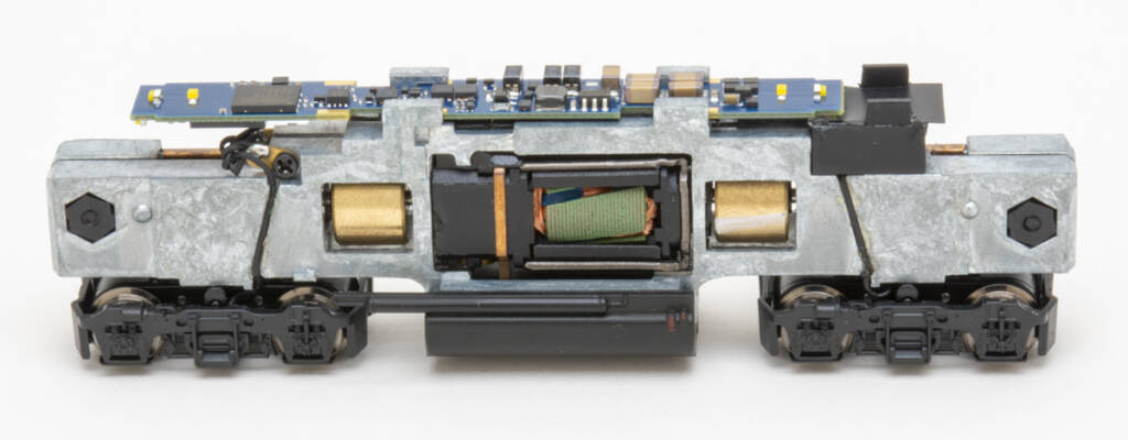 Color photo showing mechanism of N scale diesel locomotive with four-wheel trucks. 