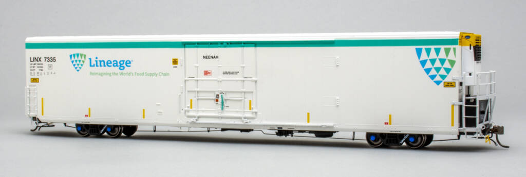 Color photo of HO scale modern refrigerator car painted white with teal, blue, green, black, and yellow graphics; yellow end stripe; and Carrier refrigeration unit on gray background. 