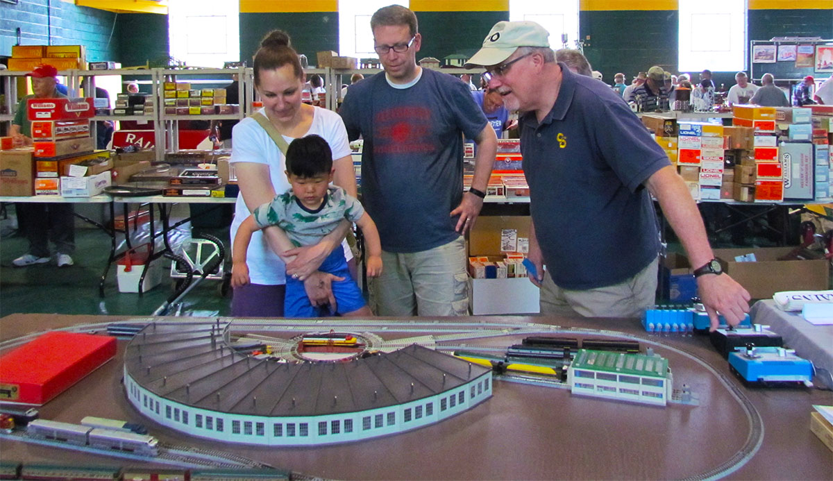 Family looking at a model railroad roundhouse. C&O Historical Society George Washington Train Show announced.