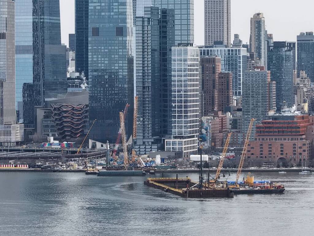 Barges in river with Manhattan skylline as backdrop