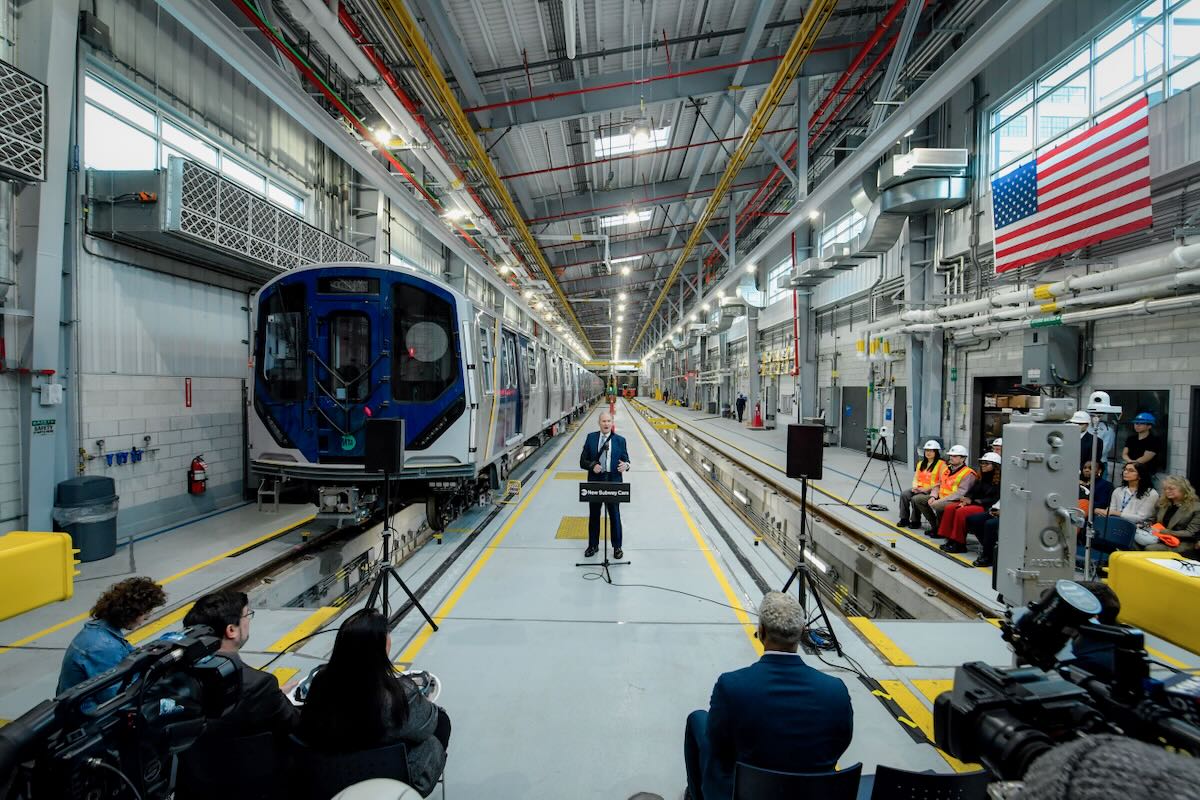 Man speaking at podium in railcar servicing facility