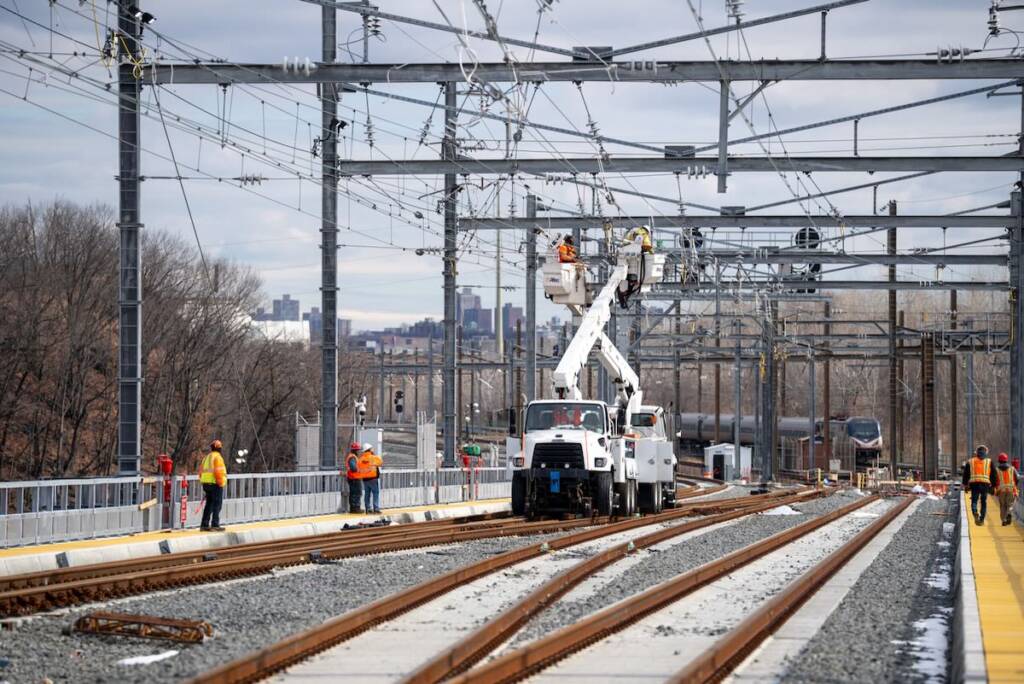 Crew members in bucket lifts prepare catenary wiring